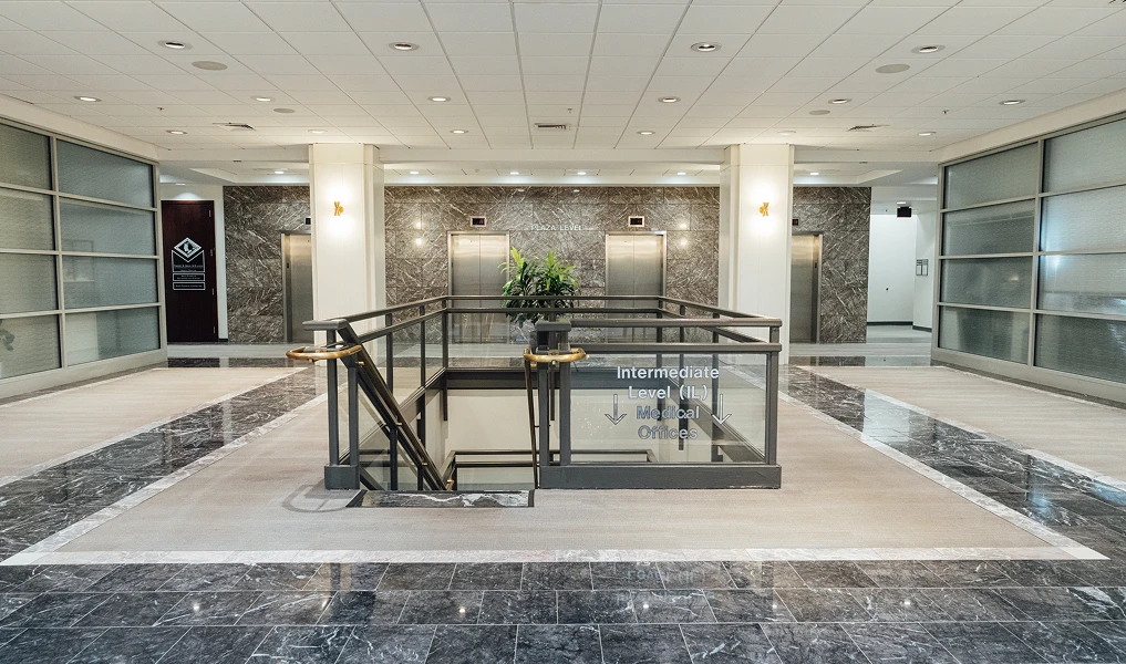 The intermediate level, featuring the down stairs and elevators in the back.